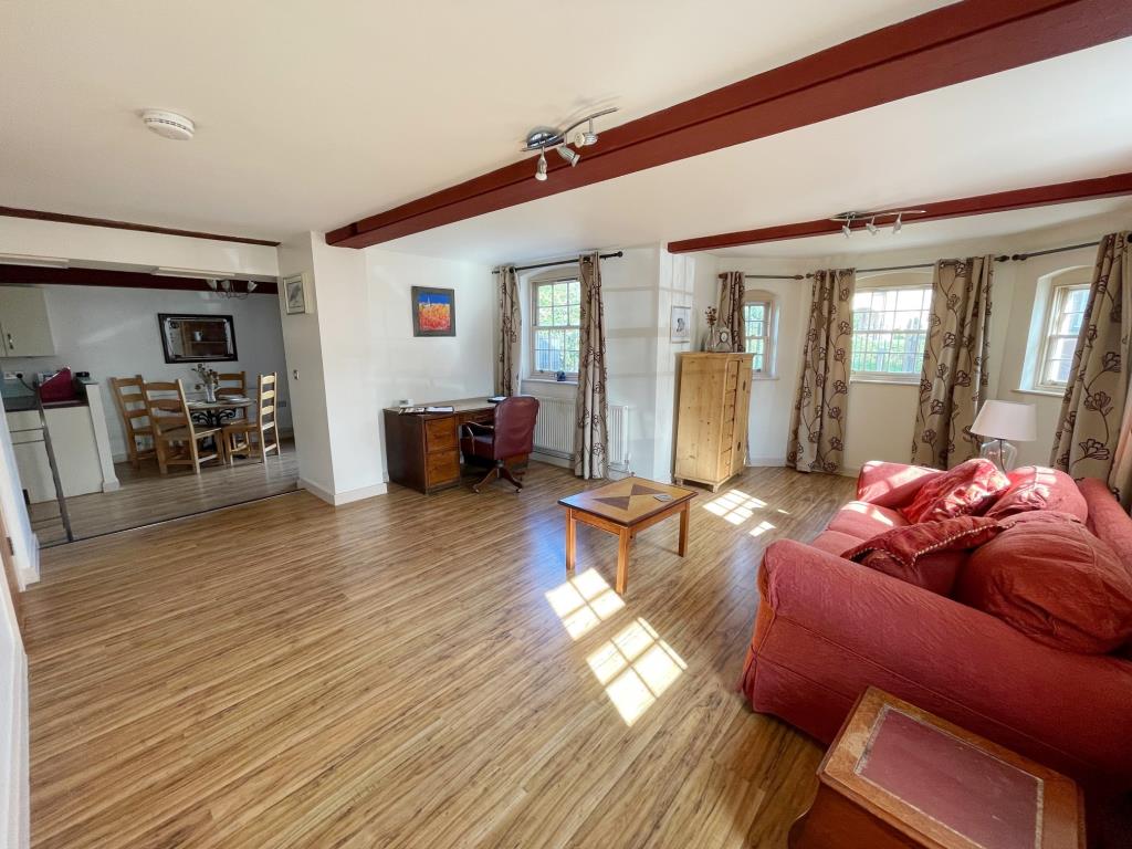 Lot: 160 - THREE-BEDROOM DUPLEX PROPERTY IN CONVERTED MILL COMPLEX - Living room opening to kitchen and dining room